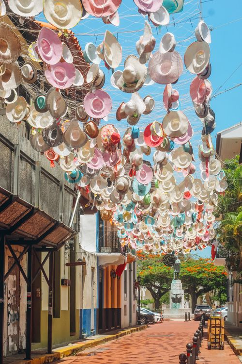 Colorful decorative hats hanging above a cobblestone street in Casco Viejo, Panama City's historic quarter