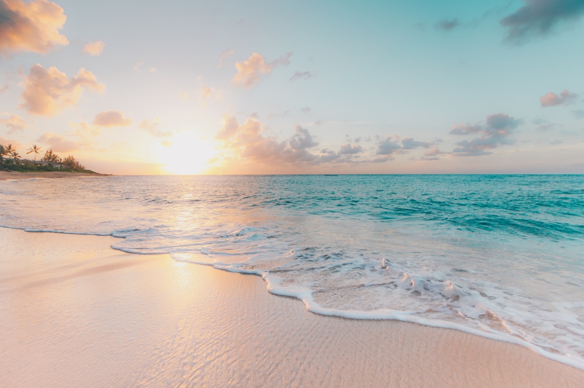 White sand beach with crystal-clear shallow water stretching to the horizon in Guna Yala